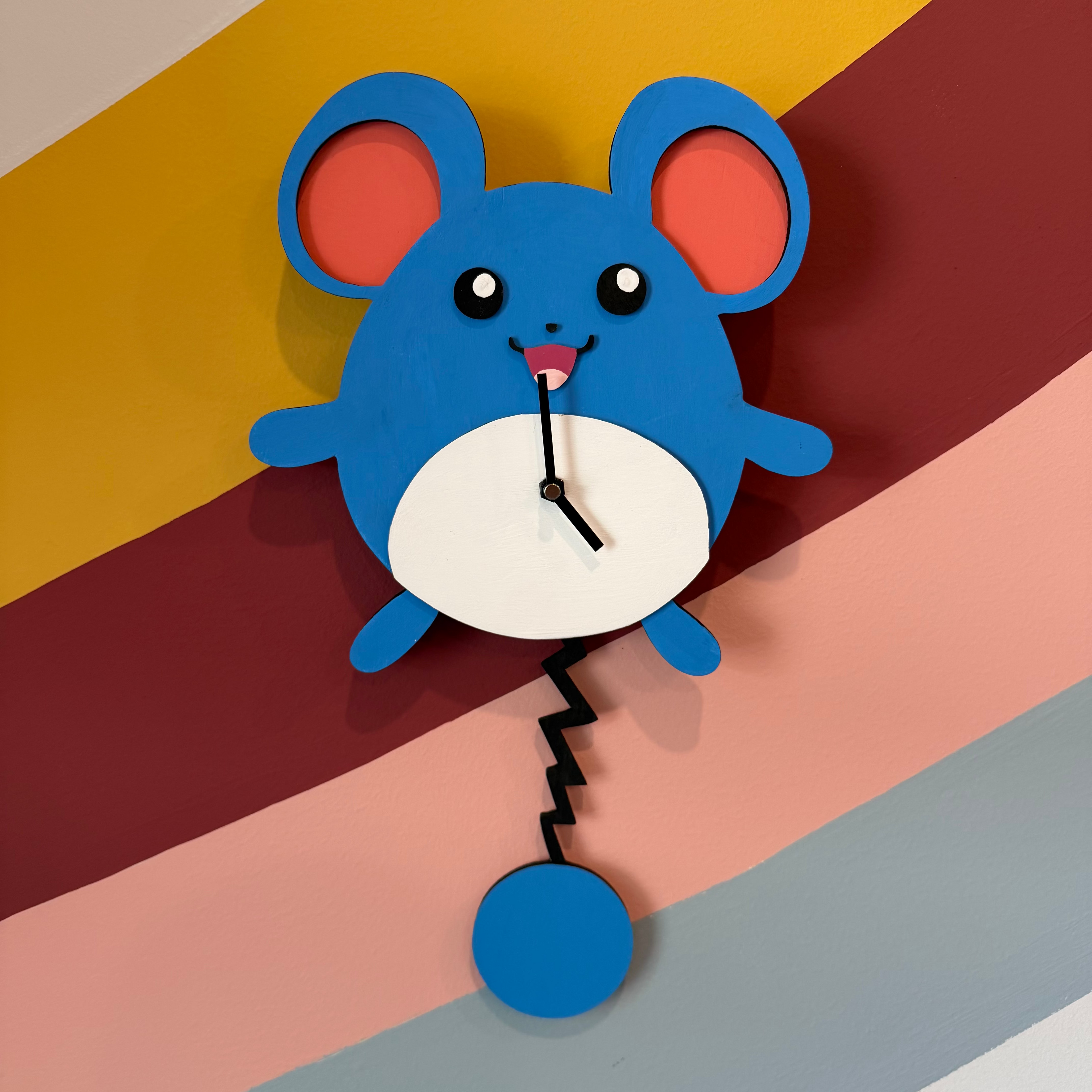 Blue mouse-shaped wall clock on a colorful striped background